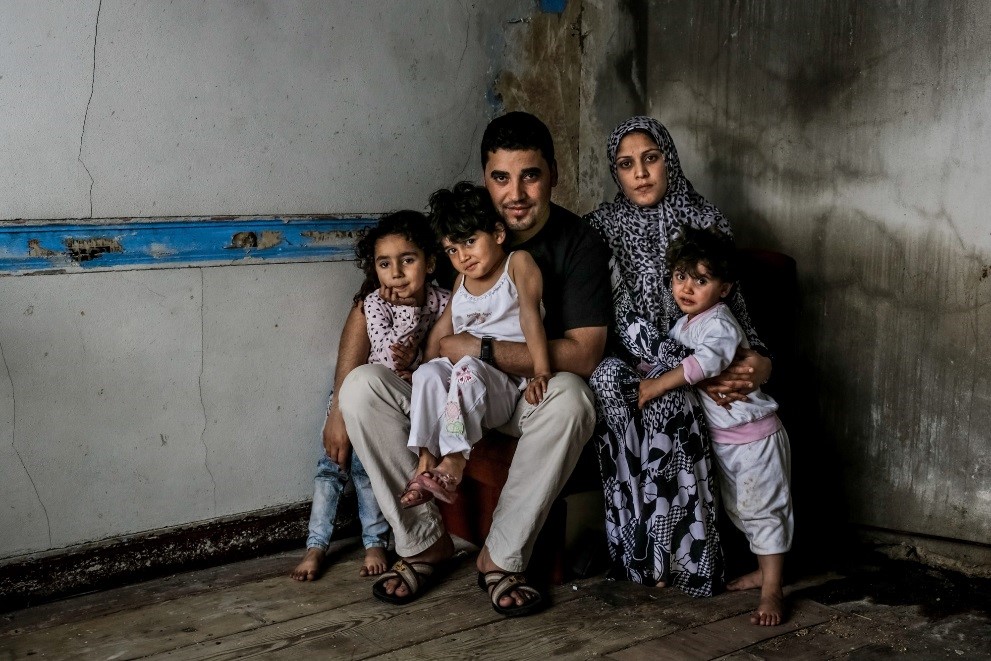 Father, mother and two children sitting in a room.